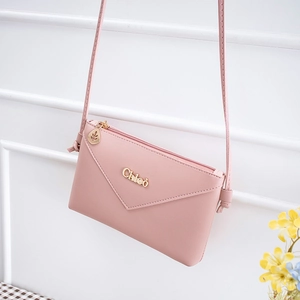 Pink crossbody envelope phone bag with gold Chleo lettering and leaf zipper charm