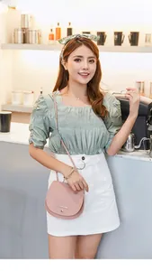 Detailed view of pink saddle crossbody bag with a magnetic snap and logo detail
