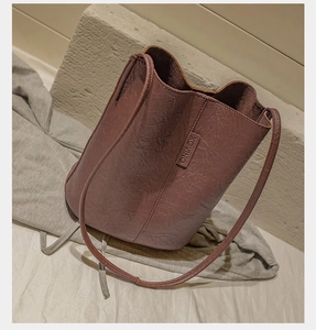 Close-up of vintage bean red bucket bag with pleated leather and XOVINO brand label