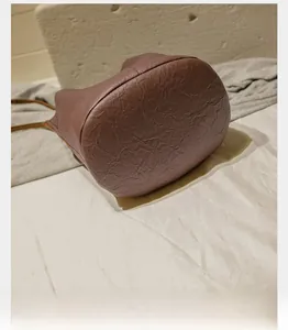 Detail view of the round reinforced base and wrinkled leather texture of bucket bag