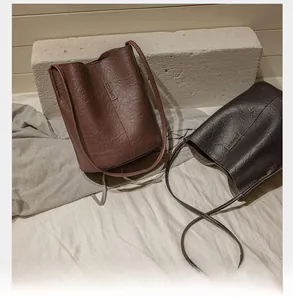 Detail of vintage bucket bags in brown and dark grey with textured synthetic leather