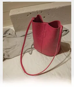 Detailed macro shot of vintage dark pink bucket bag with wrinkled leather texture