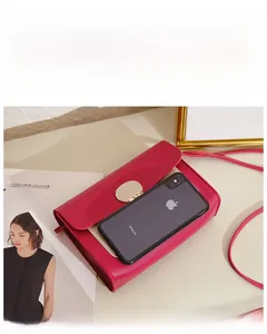 Détail du petit sac bandoulière rouge avec boucle dorée et référence de taille iPhone