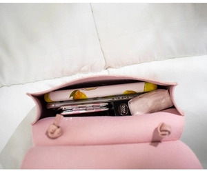 Internal view of pink saddle bag showing storage for phone, lipstick, and long wallet