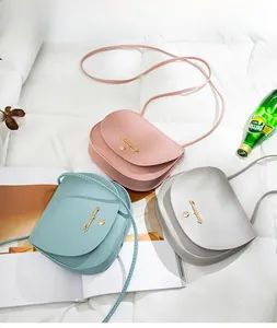 Detailed overhead view of mini saddle bags in pink, mint green and light grey on white cloth