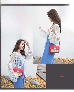 Vue détaillée du sac à bandoulière rouge et blanc avec motifs évidés et fermoir pression