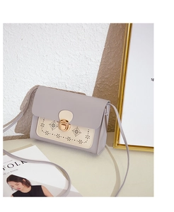 Détails du motif ajouré au laser et du fermoir coeur doré sur le sac bandoulière