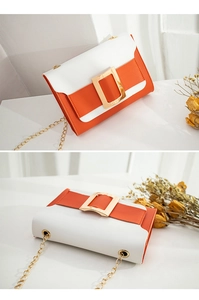 Détail du sac bandoulière bicolore orange et blanc avec boucle carrée dorée et chaîne