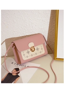 Détails du motif floral ajouré au laser et du fermoir doré sur le sac rose