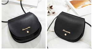 Close-up of black matte saddle bag featuring gold metal hardware and slim shoulder strap