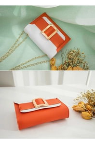 Gros plan sur le sac à chaîne en cuir orange et blanc avec boucle dorée élégante