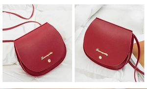 Detail view of burgundy saddle bag with gold logo and premium synthetic leather texture