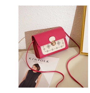 Détail du motif ajouré et du fermoir doré sur le sac bandoulière fuchsia contrasté