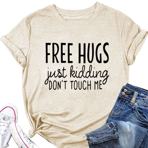 Close-up of beige t-shirt with Free Hugs print paired with jeans and sneakers