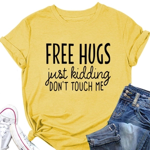 Flat lay of yellow Free Hugs slogan T-shirt paired with denim jeans and sneakers