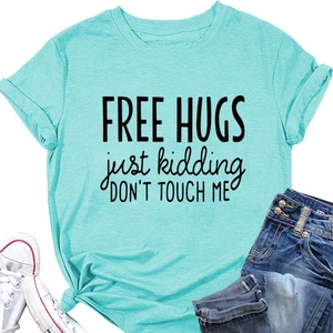 Flat lay of mint green cotton t-shirt featuring a 'Free Hugs Just Kidding' slogan print
