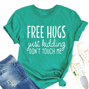 Flat lay of teal cotton T-shirt with Free Hugs slogan paired with denim and sneakers