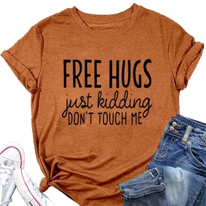 Close-up of rust orange T-shirt with Free Hugs slogan and decorative side knot detail