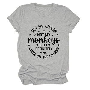 Detail eines grauen T-Shirts mit schwarzem Slogan und dekorativen Symbolen