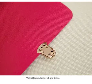 Détail de la doublure en velours magenta et de la boucle en métal doré poli du sac