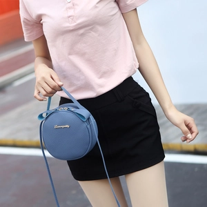 Mini round crossbody bag in blue pebble leather with top handle and golden zip closure