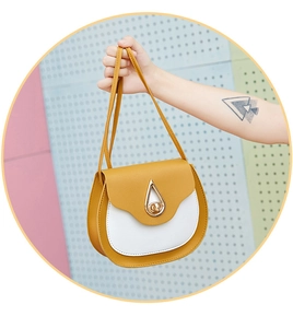 Close-up of yellow and white saddle bag with water-drop shaped gold metal lock detail