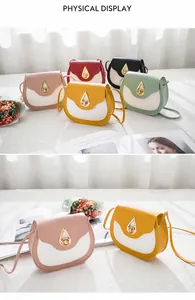 Close-up of contrast color saddle bag with golden water-drop lock on white table