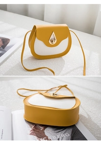 Detail of yellow and white saddle bag with golden teardrop-shaped hardware lock