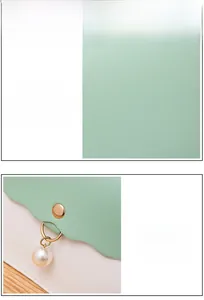 Detailed view of light green lychee textured PU leather with elegant pearl pendant charm