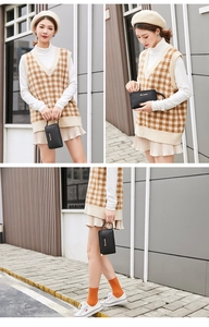 Detail of black litchi grain leather clutch bag featuring a gold zipper and wrist strap