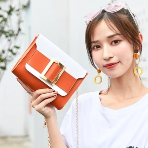 Sac bandoulière tendance bicolore orange et blanc avec grande boucle dorée et chaîne