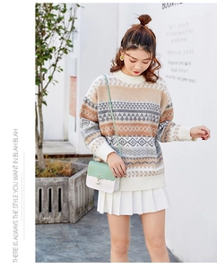Close-up of a stylish contrast color crossbody bag paired with a knit sweater and pleated skirt