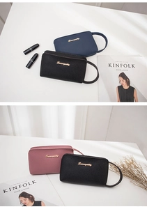 Detail showing high-quality lychee pattern faux leather and gold logo on wristlet