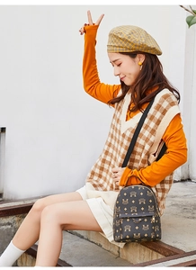Mannequin portant un petit sac à dos marron à monogramme dans un cadre extérieur