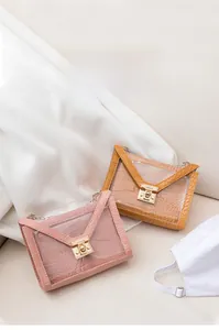 Dettaglio di borse gelatina rosa e gialle in PVC trasparente con texture coccodrillo