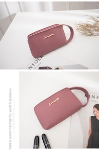 Pink litchi texture leather clutch bag with golden logo and side wrist strap detail
