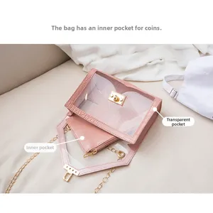 Dettaglio della pochette rosa con motivo a coccodrillo in una borsa a tracolla trasparente