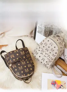 Détail de mini sacs à dos vintage à monogramme marron et blanc sur tapis de fourrure