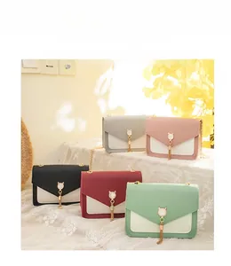 Detail showing cat-ear pearl buckles and golden tassels on contrast color crossbody bags