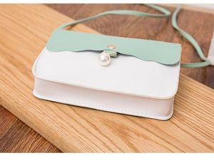 Detail of mint green wave flap and pearl decor on white small crossbody bag