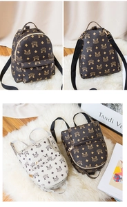 Vue détaillée de mini sacs à dos à monogramme marron et beige avec zips dorés élégants