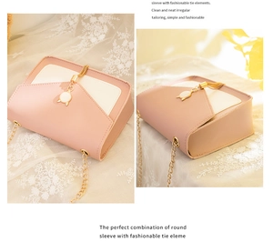 Detailed view of pink and white crossbody bag with cat ear charm and gold chain strap