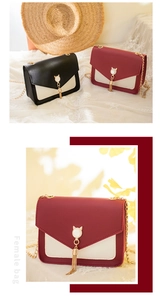 Detail of elegant two-tone crossbody bags with gold cat clasp and tassel decoration