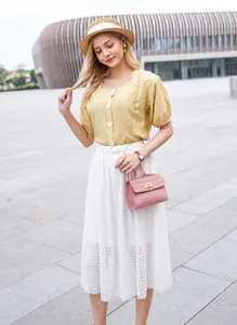 Détail du petit sac carré rose à texture crocodile avec fermoir métallique et bandoulière