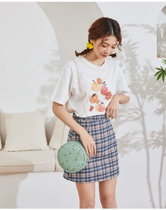 Detail of mint green round crossbody bag with floral embroidery and gold chain strap