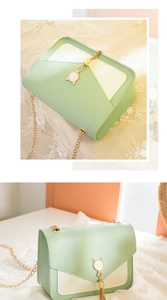 Detail of mint green and cream square crossbody bag with cat ear tassel and gold chain