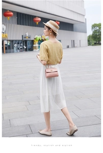 Petit sac rose à motif crocodile avec chaîne dorée porté par un mannequin au soleil