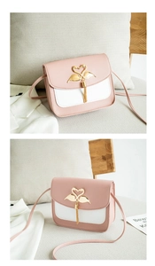 Detail der Handtasche in Rosa und Weiß mit goldenem Schwanenverschluss und Quasten