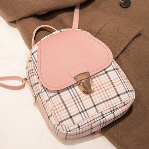 Mini plaid backpack with pink leather flap and gold metal buckle on brown wool coat