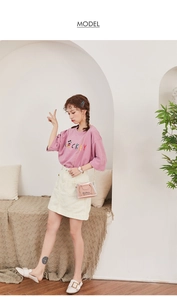 Detailed view of clear bucket bag with pink interior pouch styled with casual summer outfit